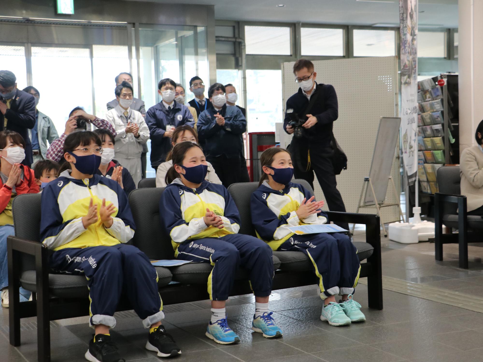 椅子に座って溝畑樹蘭選手を応援するこどもたち