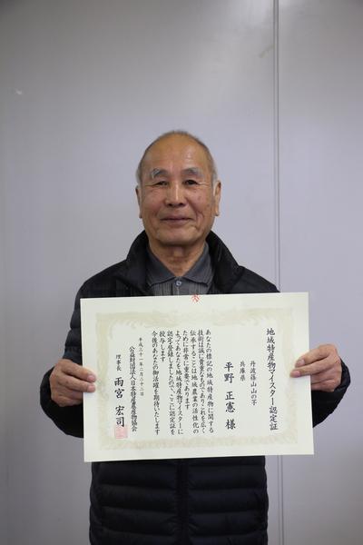 笑顔で賞状を持つ、平野 正憲さんの写真