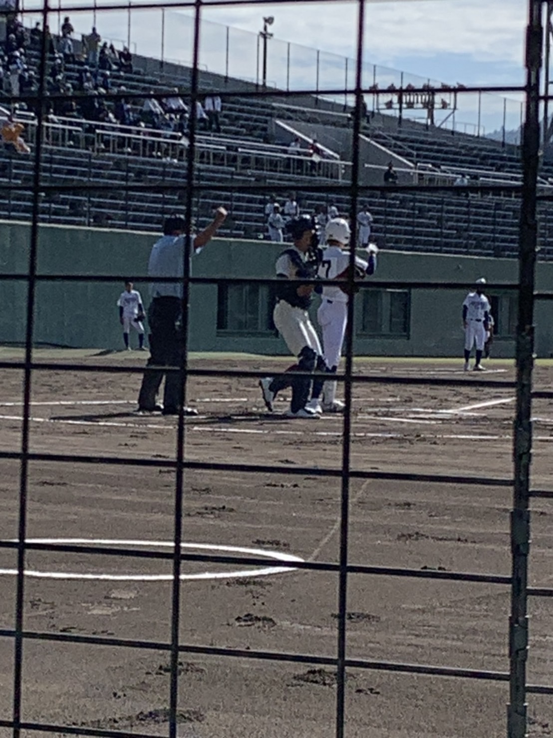 野球の試合で、主審がストライクと判断し、キャッチャーはボールをピッチャー戻そうとしている。