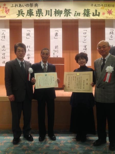 I兵庫県川柳祭で最優秀受賞の酒井 真由さん(篠山市)、小林 優さん(篠山市)が賞状を持って市長らと4人で記念撮影している写真