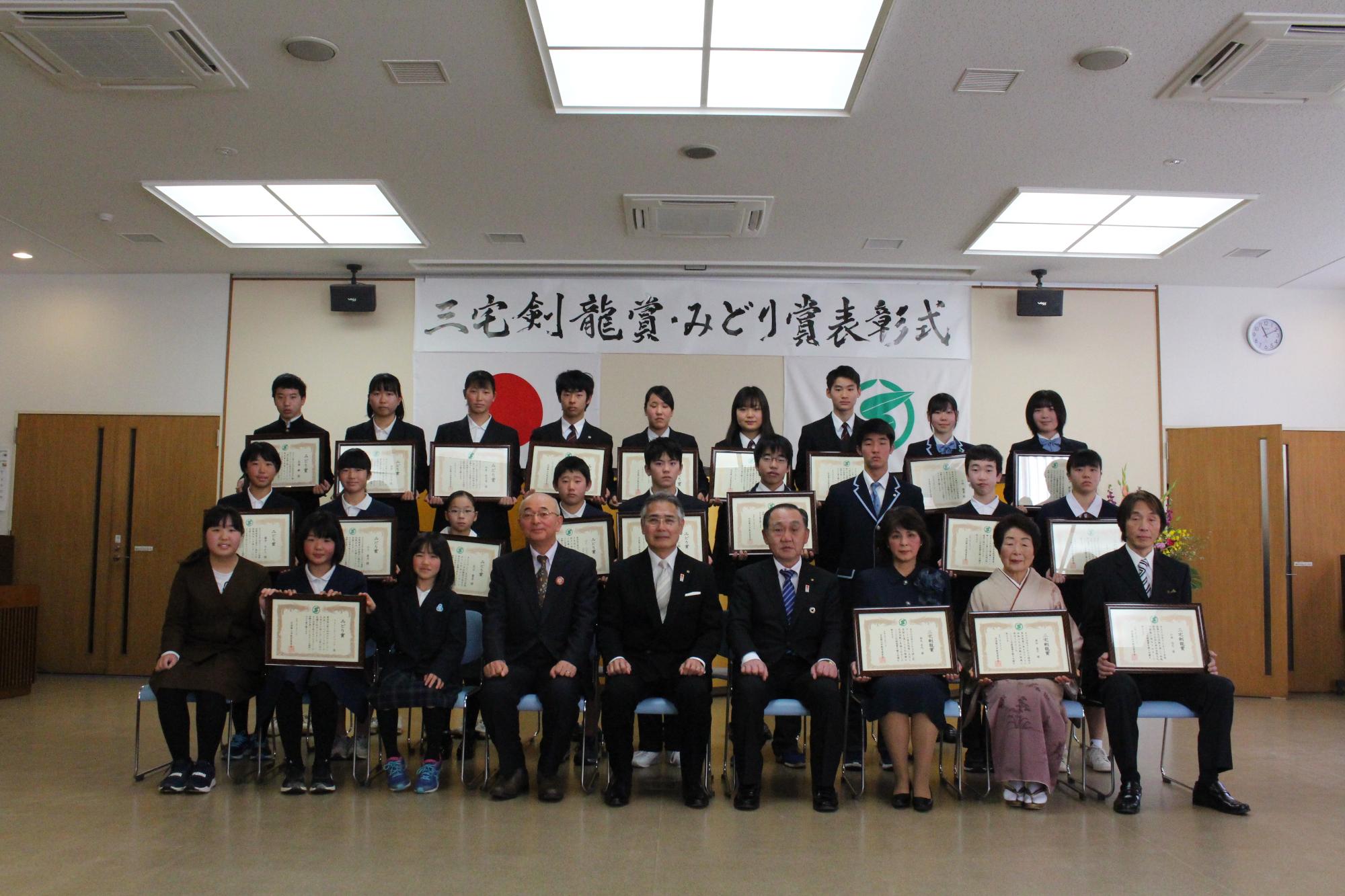 横に3列になって、前川教育長・酒井市長・森本議長が前列の真ん中に座り、受賞者の皆さんは表彰状を持たれて写っている記念写真