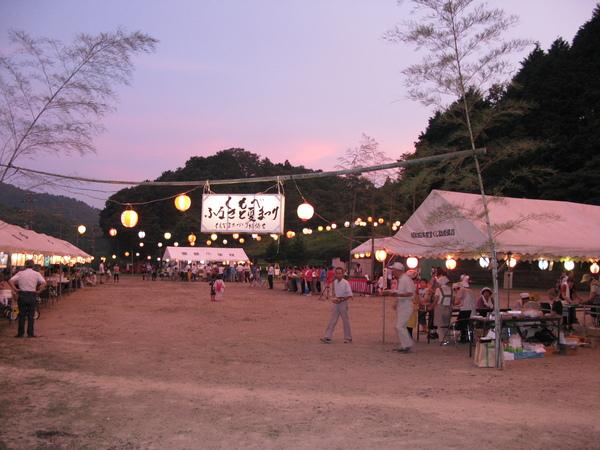 辺り一面薄暗くなりテントに提灯の明かりが照らされている写真