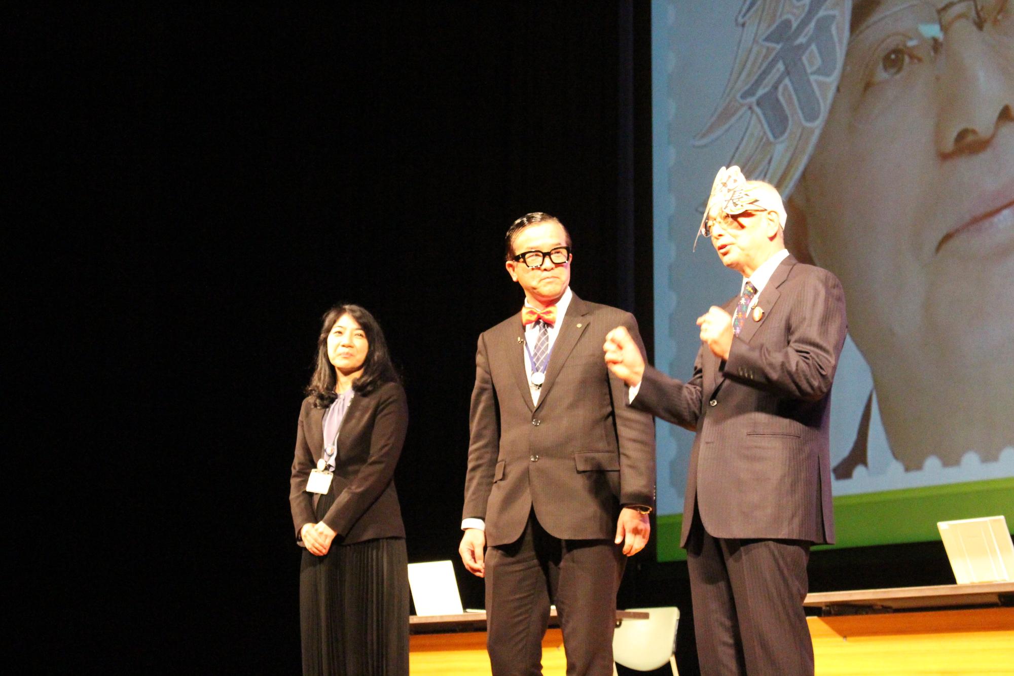 イケメン市長と書かれた被り物を被った酒井市長と、市長のほうを見て話しを聞く秘書課長と秘書