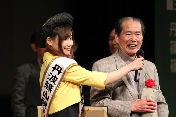丹波篠山観光大使が大賞の合原 一夫さんへマイクを向けている写真