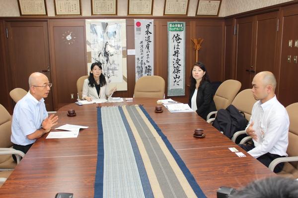 市長室にて西本 達也さんが市長と向かい合って座っており、熱心に話をしている様子の写真