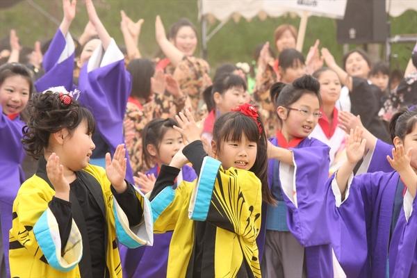 チーム「北翔」の黄色の法被を着た女の子が両手を上に上げて手をたたいている踊りをしている写真