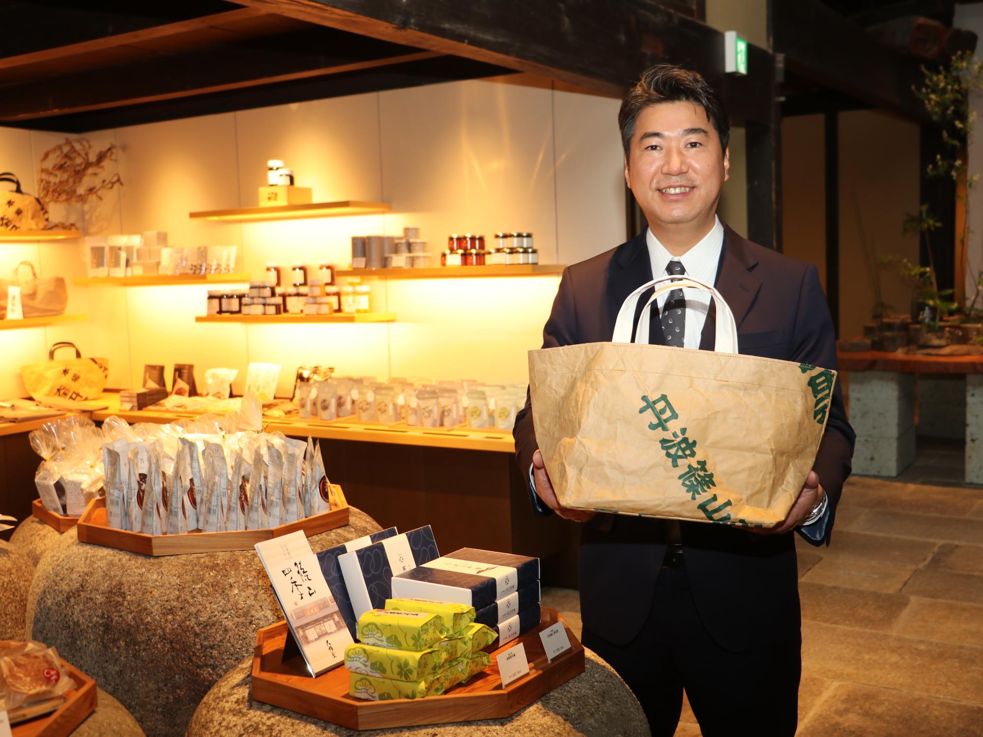 丹波篠山と入ったトートバッグを手にしている男性