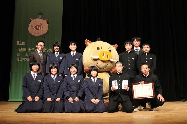 篠山東中学校生徒会のみなさんが賞状とお祝い金を持って、「まるいの」と記念写真