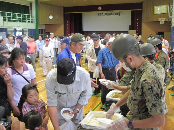 青野原陸上自衛隊の皆さんによるカレーの炊き出しの配膳の写真