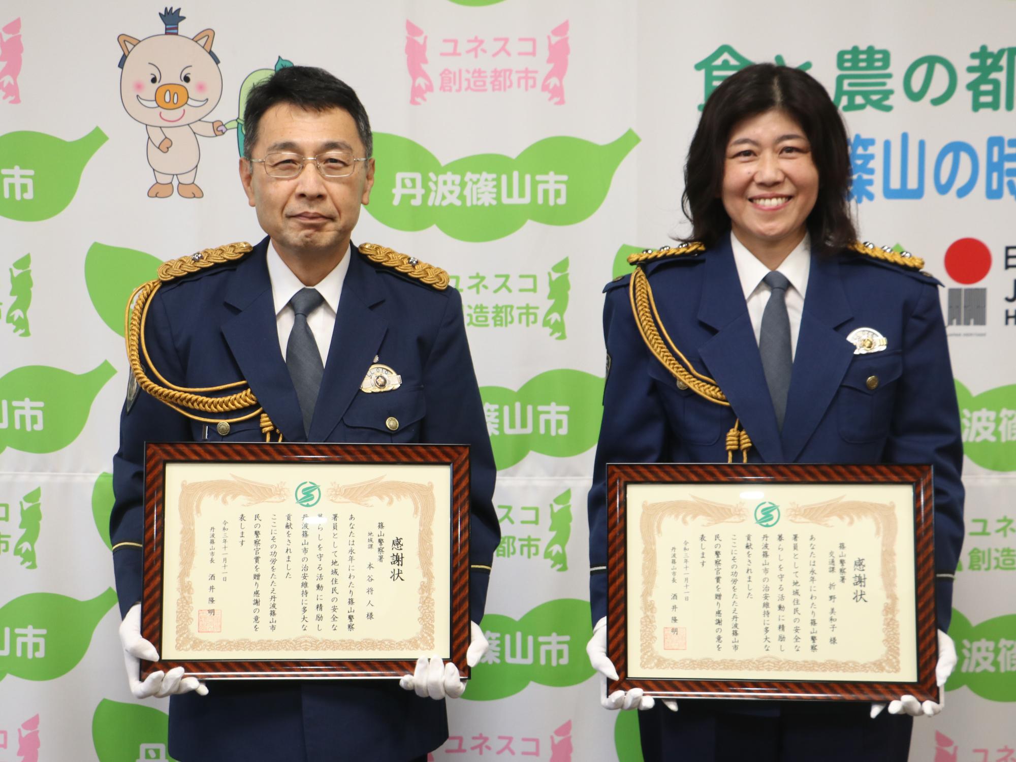 式典用の制服を着た警察官の方二人が感謝状を手にしている