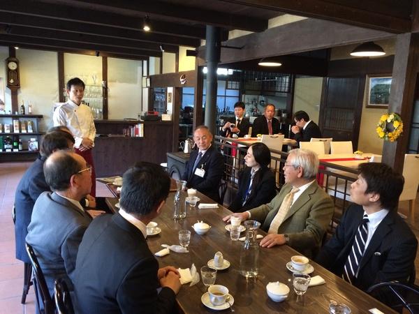 喫茶店の中で職員と一緒にシェフの話を聞いている文化庁長官の写真