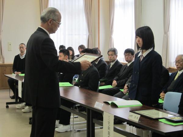 「三宅剣龍賞」を教育委員長から授与されている制服姿の女学生の写真
