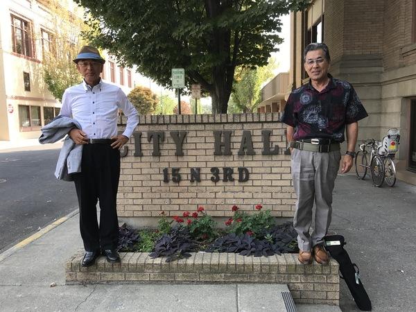 市長と男性がワラワラ市役所の看板の前に立っている写真