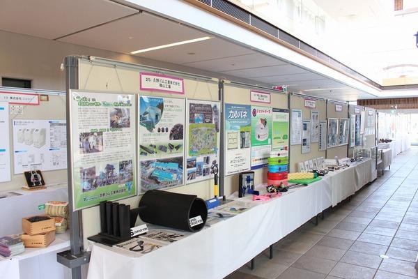 机の上に展示されている、様々な製品と、企業や製品の案内資料の写真