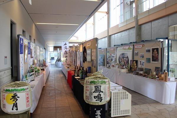 大きな酒樽や、机の上に並べられている様々なお酒、様々な製品と展示されている紹介資料の写真