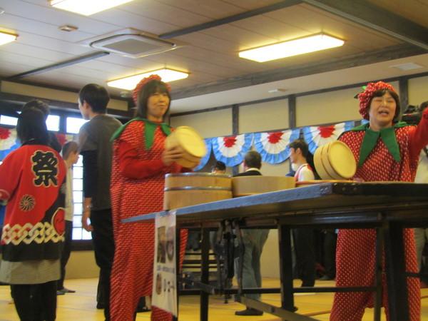 イチゴのコスチュームを着た2人の女性が桶で卓球をしている写真