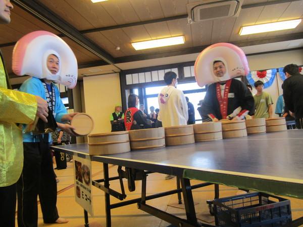 かまぼこの被り物をした男性二人が桶で卓球をしている写真