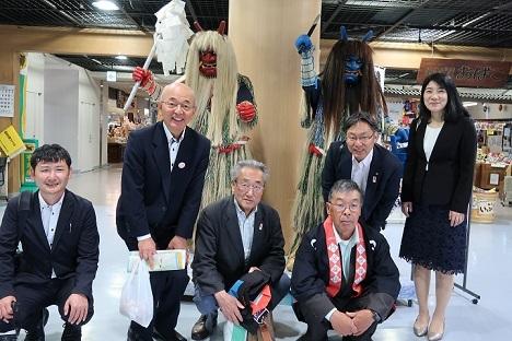 赤鬼と青鬼の格好をした人の前で、市長、男性4名、女性と笑顔で記念写真