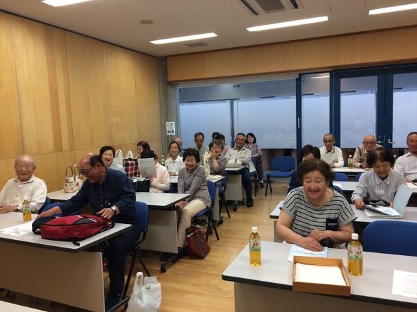 菊花同好会の総会の出席者が会議室に座っており、笑顔で写っている様子の写真