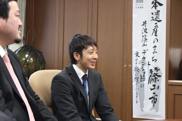 スーツを着て市役所に挨拶に来てくれた角谷選手とトレーナーの写真
