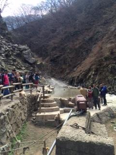 猿が温泉に入る有名な場所を観光客が見ている写真