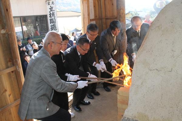 市長と男性達が窯に火を入れている写真