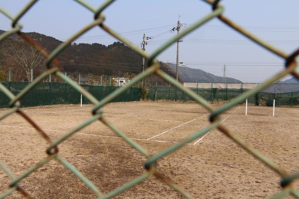 グラウンドを金網の後ろから見た写真