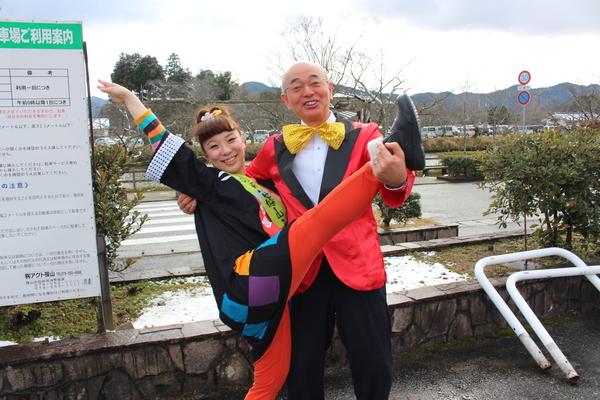 森田まりこさんが右手右足を上にあげポーズをとりその右足を市長が左手で支え右手で背中を支えて笑顔でポーズの写真