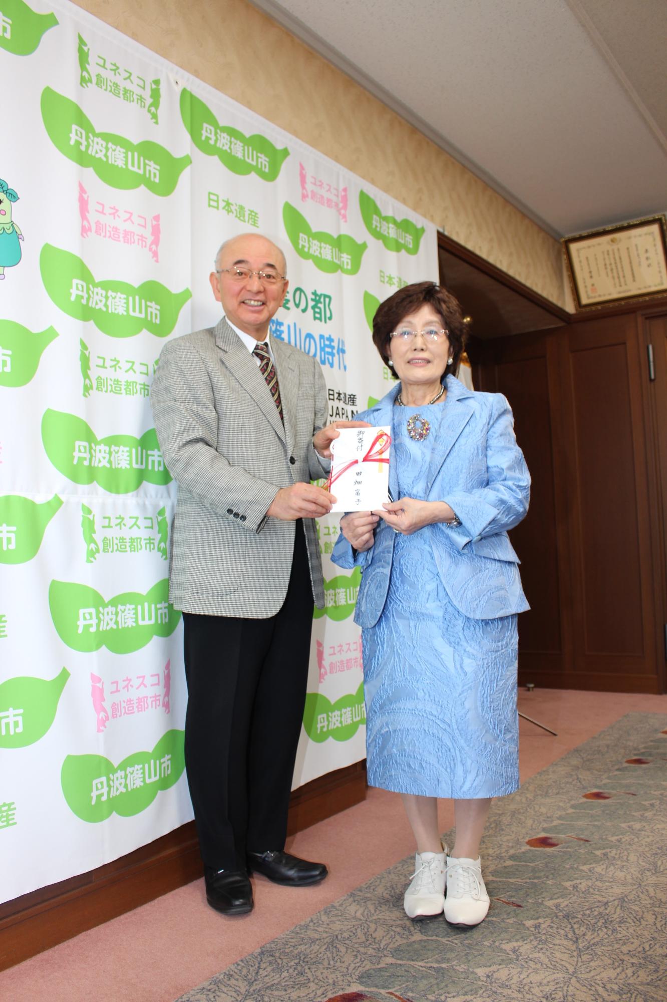 白いおしゃれな靴をはいた田畑富子さんと、酒井市長