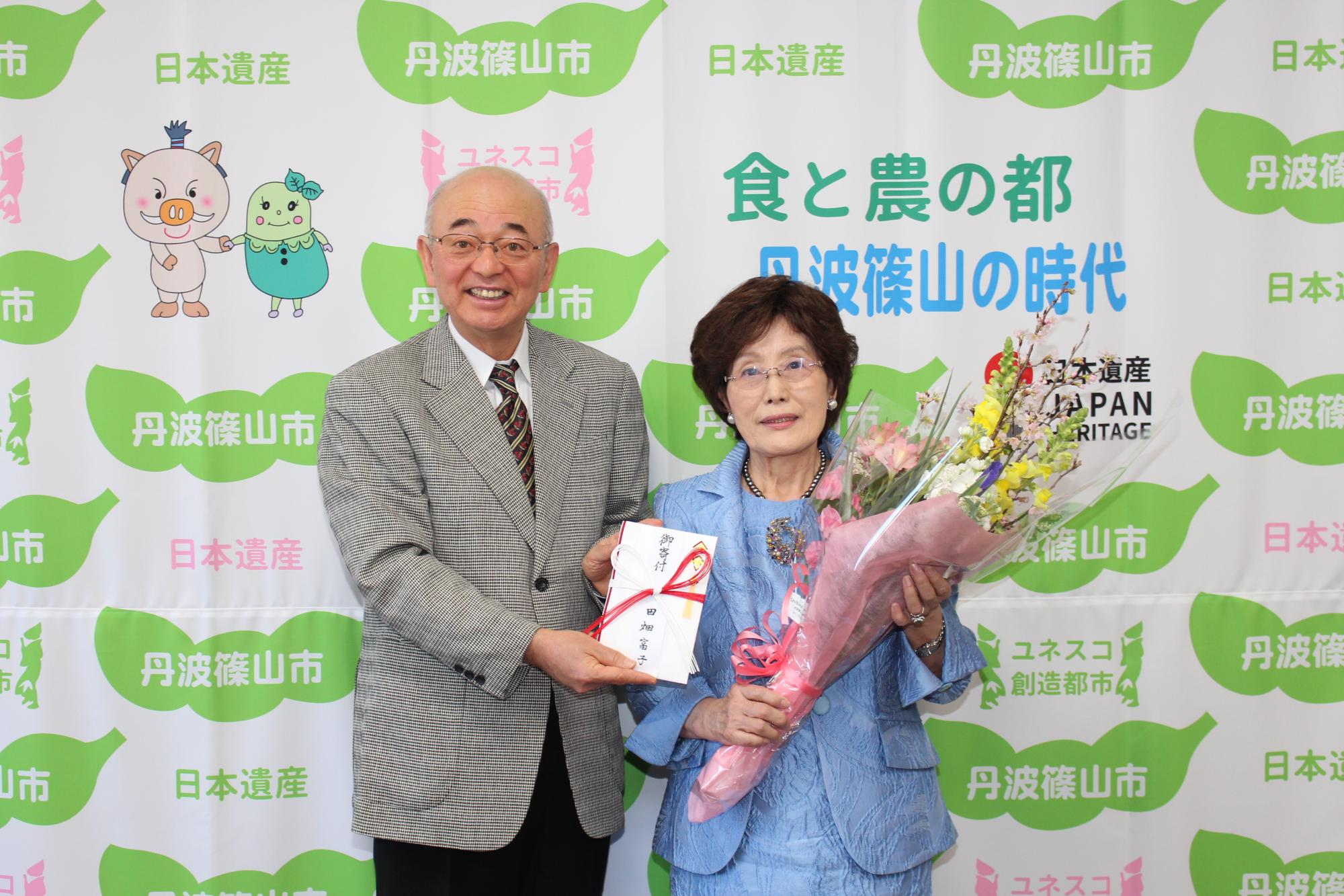 花束を持つ田畑富子さんと、酒井市長