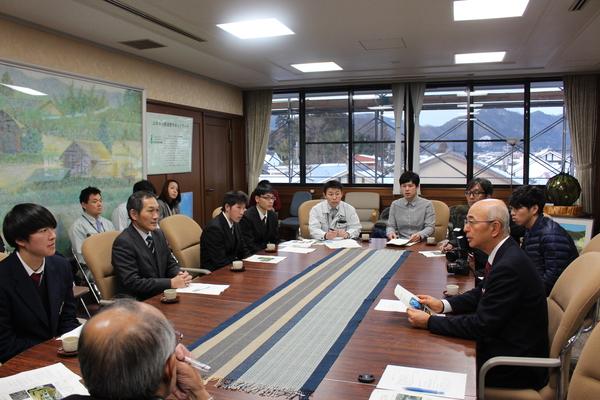 市長室にて、市長の前に黒いブレザーを着た高校生と青いネクタイをしている男性が座っており、市長の話を聞いている様子の写真