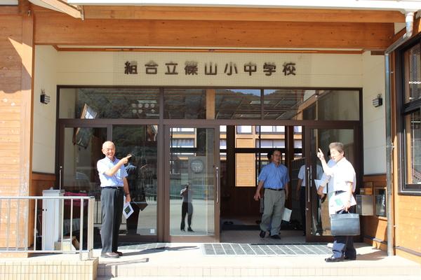 組合立篠山小中学校の入り口に立ち、指さしている市長と、男性の写真