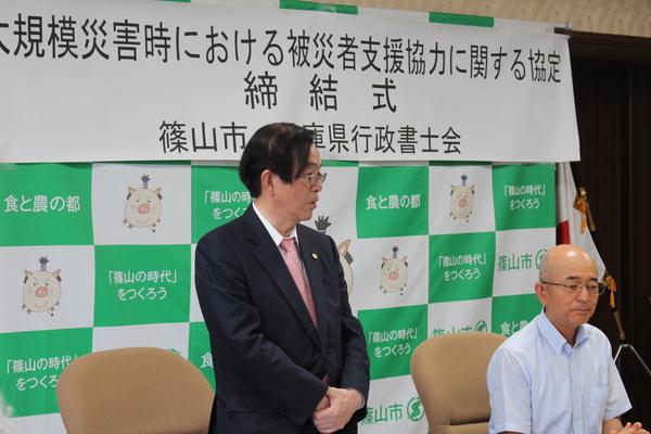 市長が横に座り、兵庫県行政書士会の村山会長が立って話をしている写真