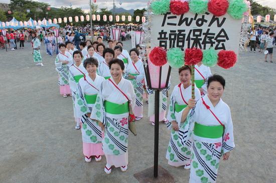 「たんなん音頭保存会」のプラカードを持った女性と仲間で記念撮影写真