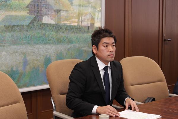 応接室に着席し資料に手をおく菟原 元彦委員長の写真