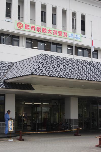 市役所の建物に「都市景観大賞受賞」と大きな横断幕が飾られている写真