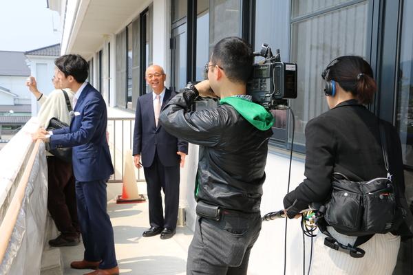 一般の方とアナウンサーの方が桜を見ながら話をしている写真