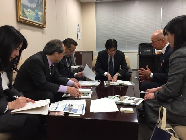 正面に座っている総務省財政局長の黒田さんが机の上の資料を興味深く見ており、市長が熱心に説明をしている様子の写真