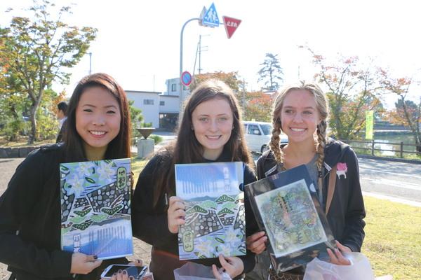 3名の女性が篠山市のパンフレットを手に持ちアップで記念写真