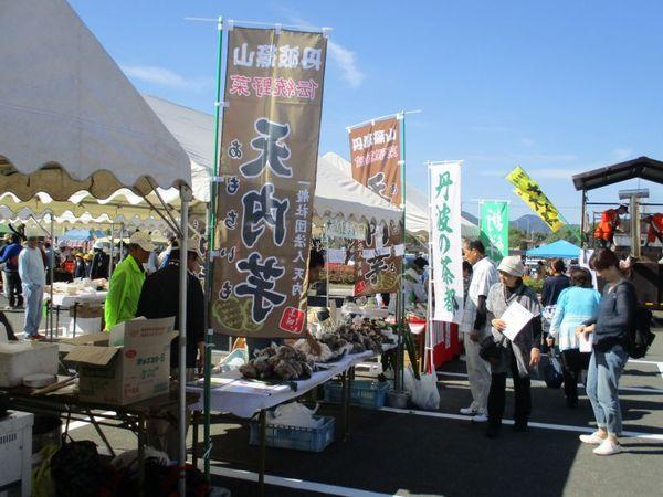 テントがたくさん並んで芋やお茶などが販売されている写真
