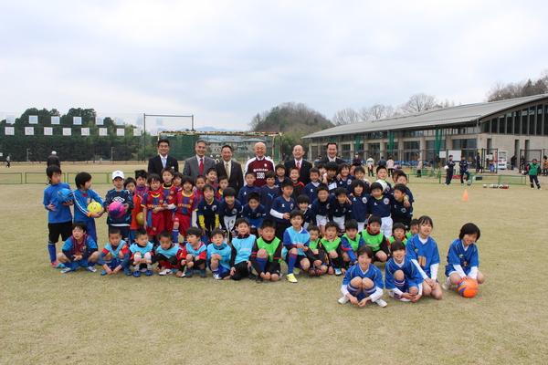 近藤 雅彦社長,市長、関係者及びサッカー少年・少女達がグラウンドに集まって写っている集合写真