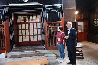 建物の前で女性と市長が遠くを見ている写真
