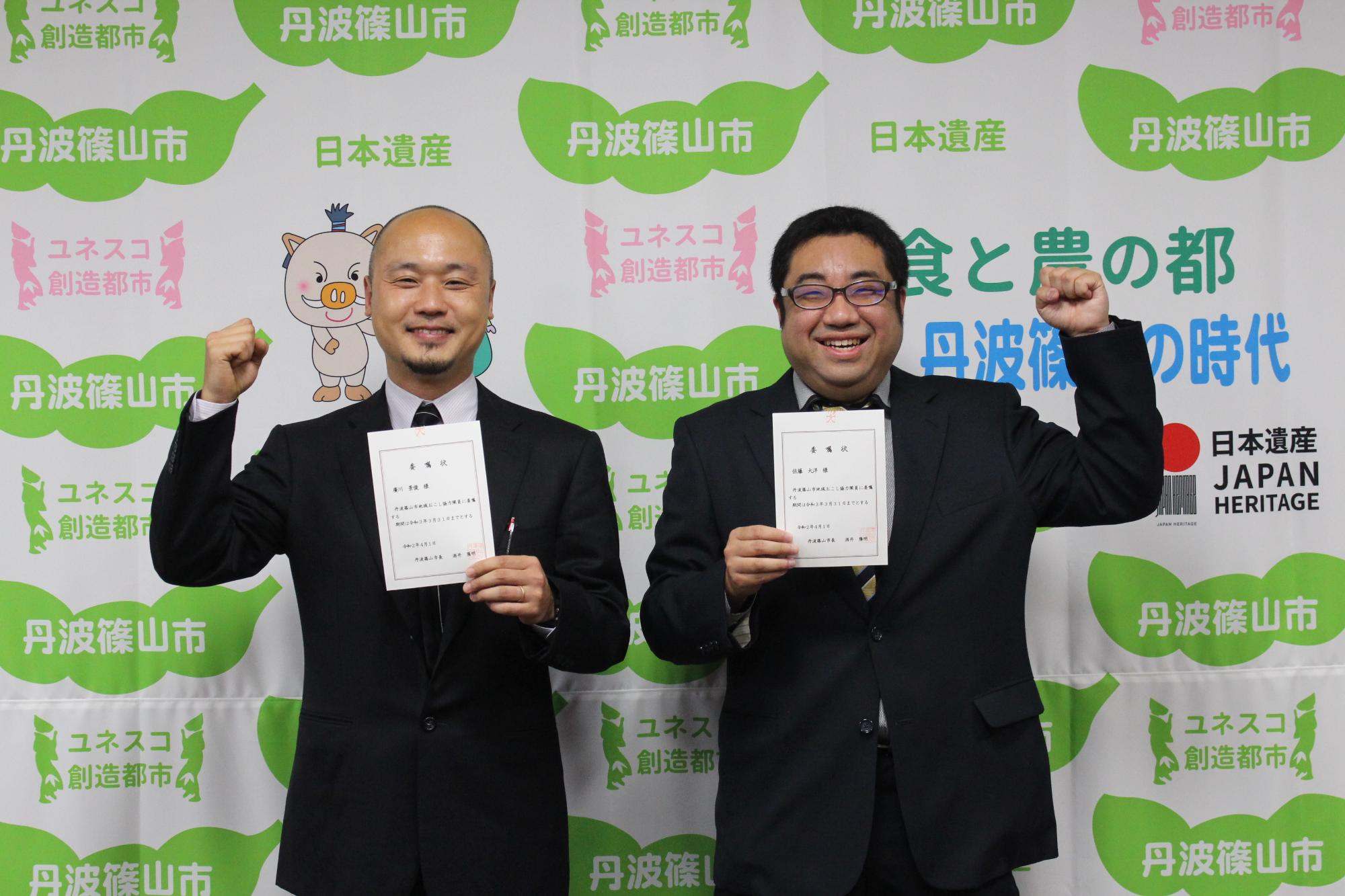 委嘱状を手にガッツポーズをとる二人の隊員