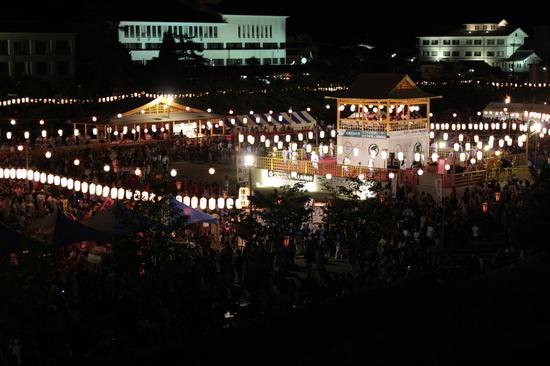 夜のお祭りが行われ沢山の提灯がついている様子を上空からうつした写真