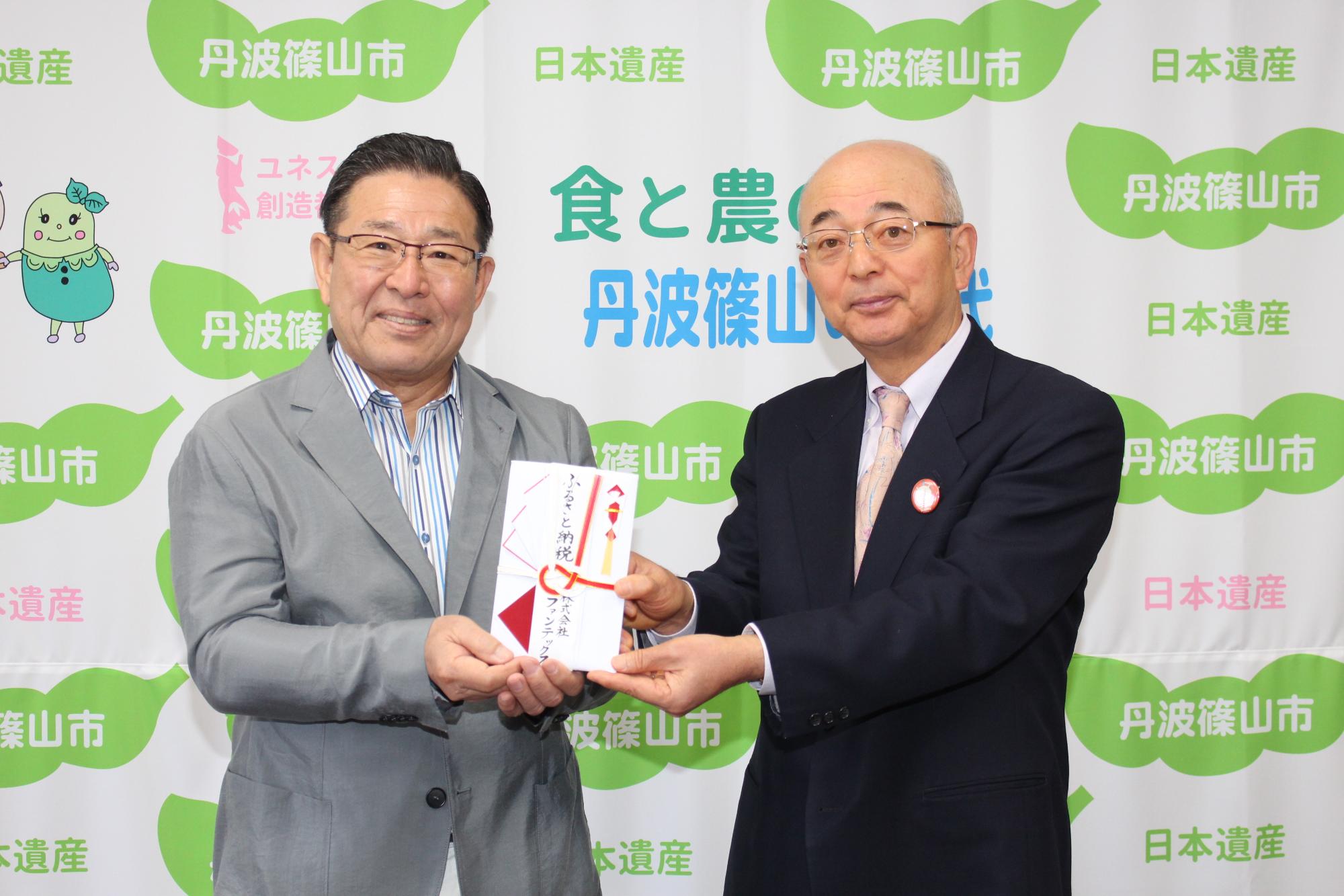 寄付金を手に微笑む酒井市長と内藤氏