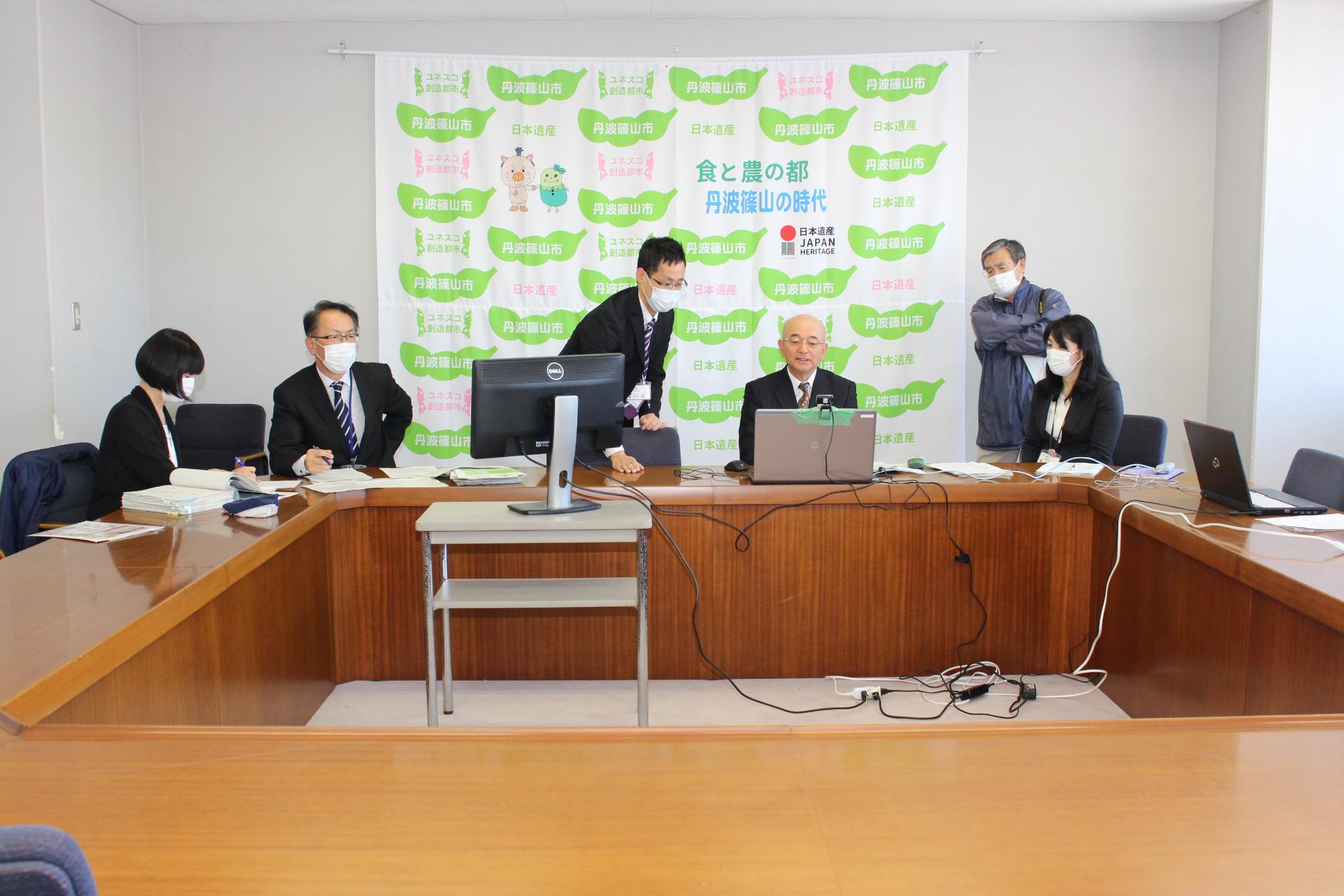 テレビ会議を行う市長と市職員