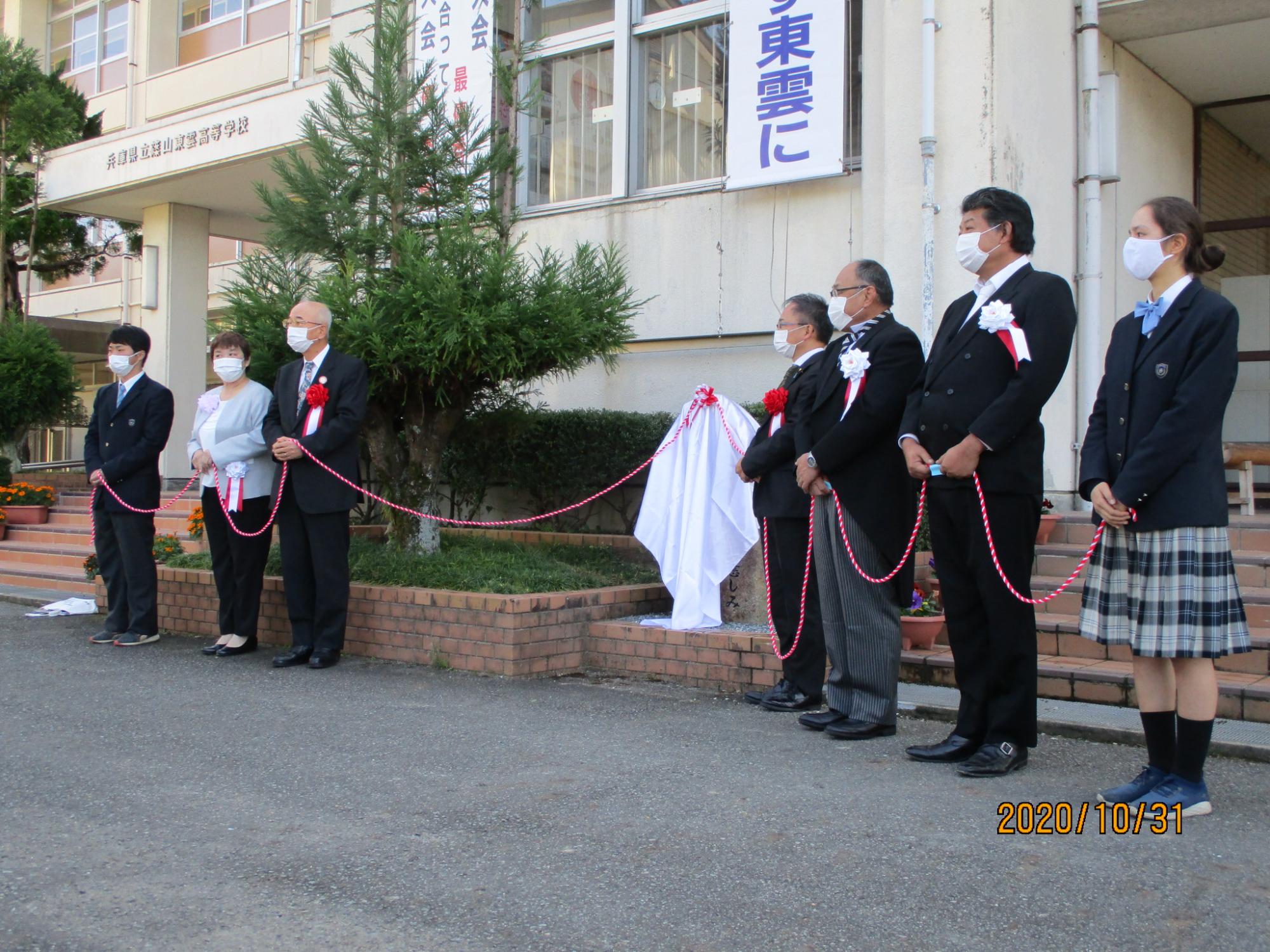 除幕式のロープを持つ関係者