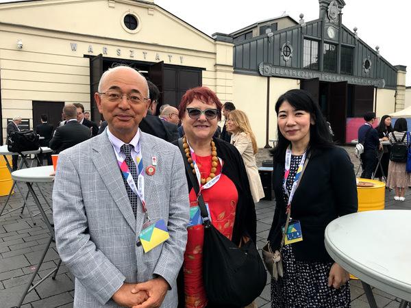 市長、赤い髪色の外国人の女性、日本人の女性の3人が並んでいる写真