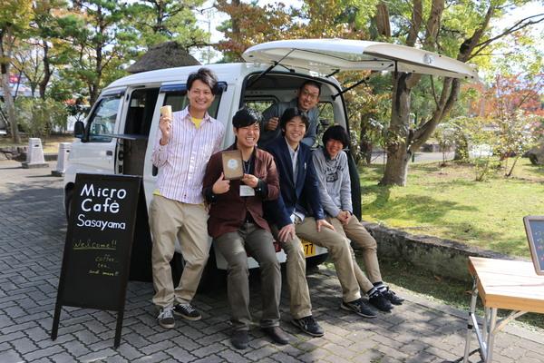 移動カフェの車に5人の男子学生が腰かけて笑っている写真