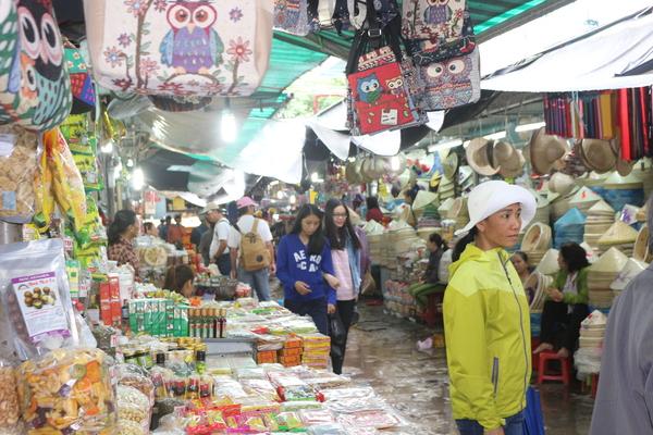 ベトナムの市場に、お菓子や帽子がたくさん飾られている写真